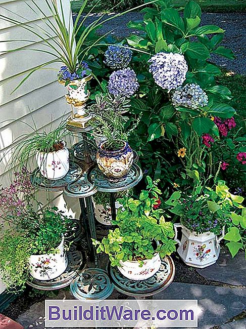 Ein antiker Pflanzenstand dient als Außenspeisekammer, die Vintage-Behälter mit verschiedenen Kräutern gefüllt.
